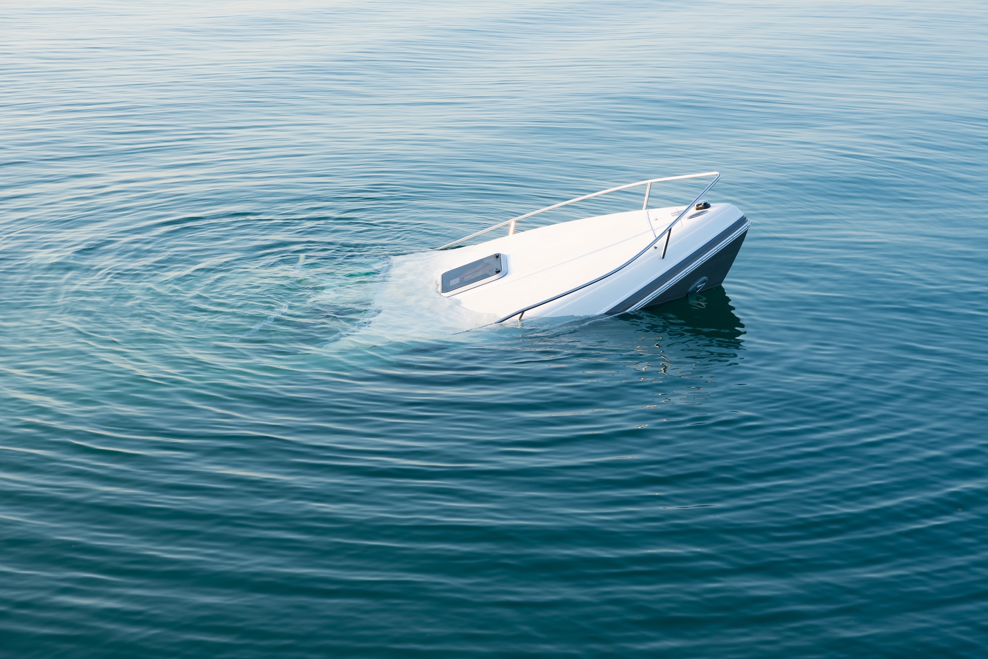A boat sinking in the water, how to avoid swamping your boat concept. 