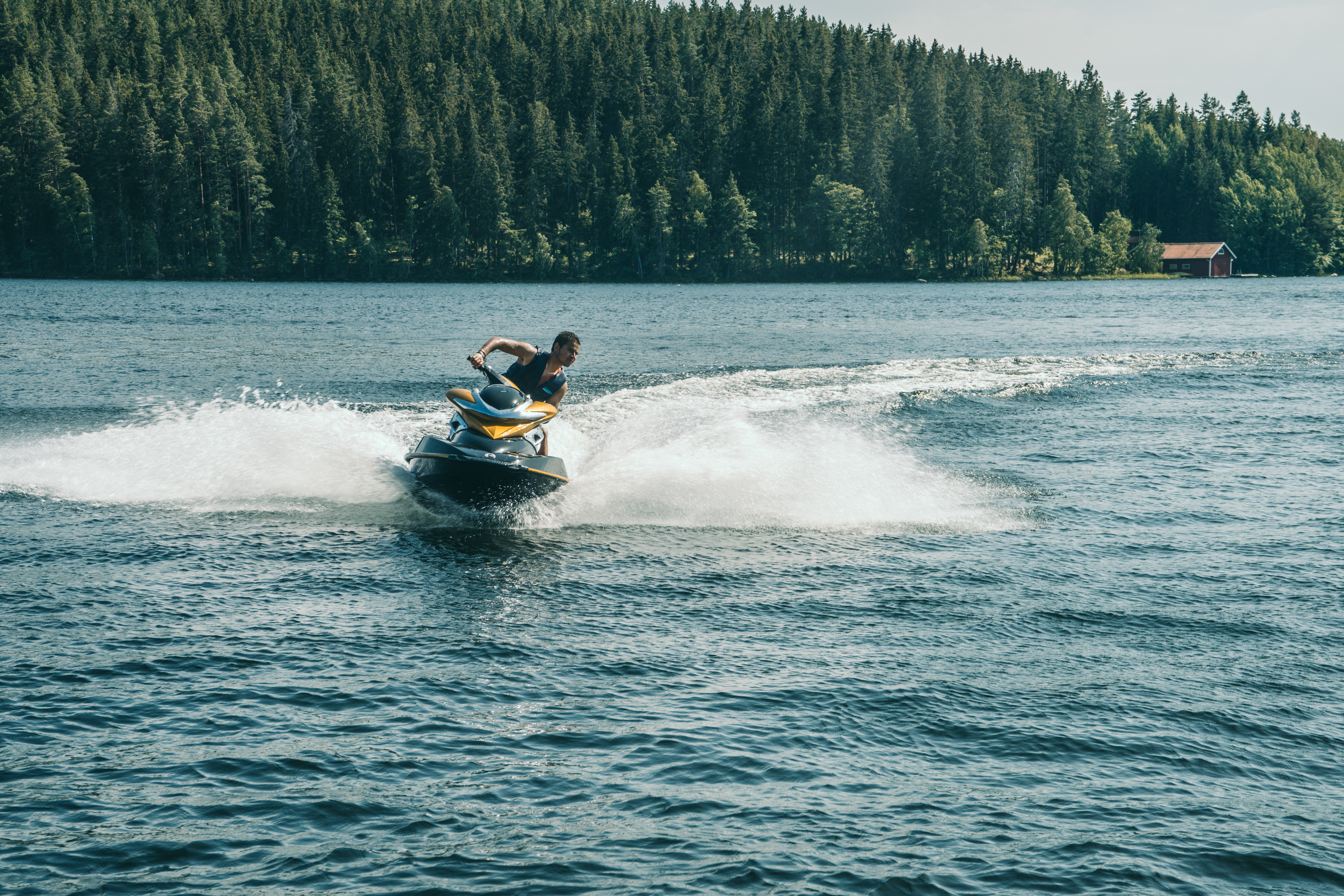 A man drives a jet ski on the water, do you need a license to drive a jet ski concept.