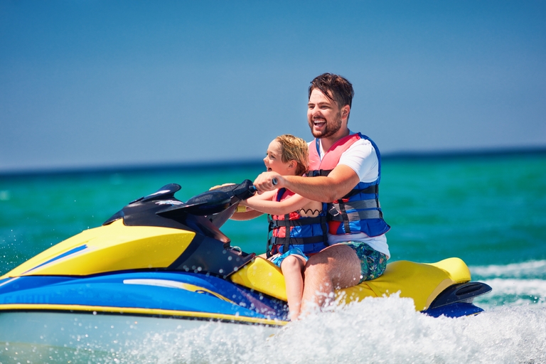 A man and child enjoy a jet ski on the water, boating safety concept. 