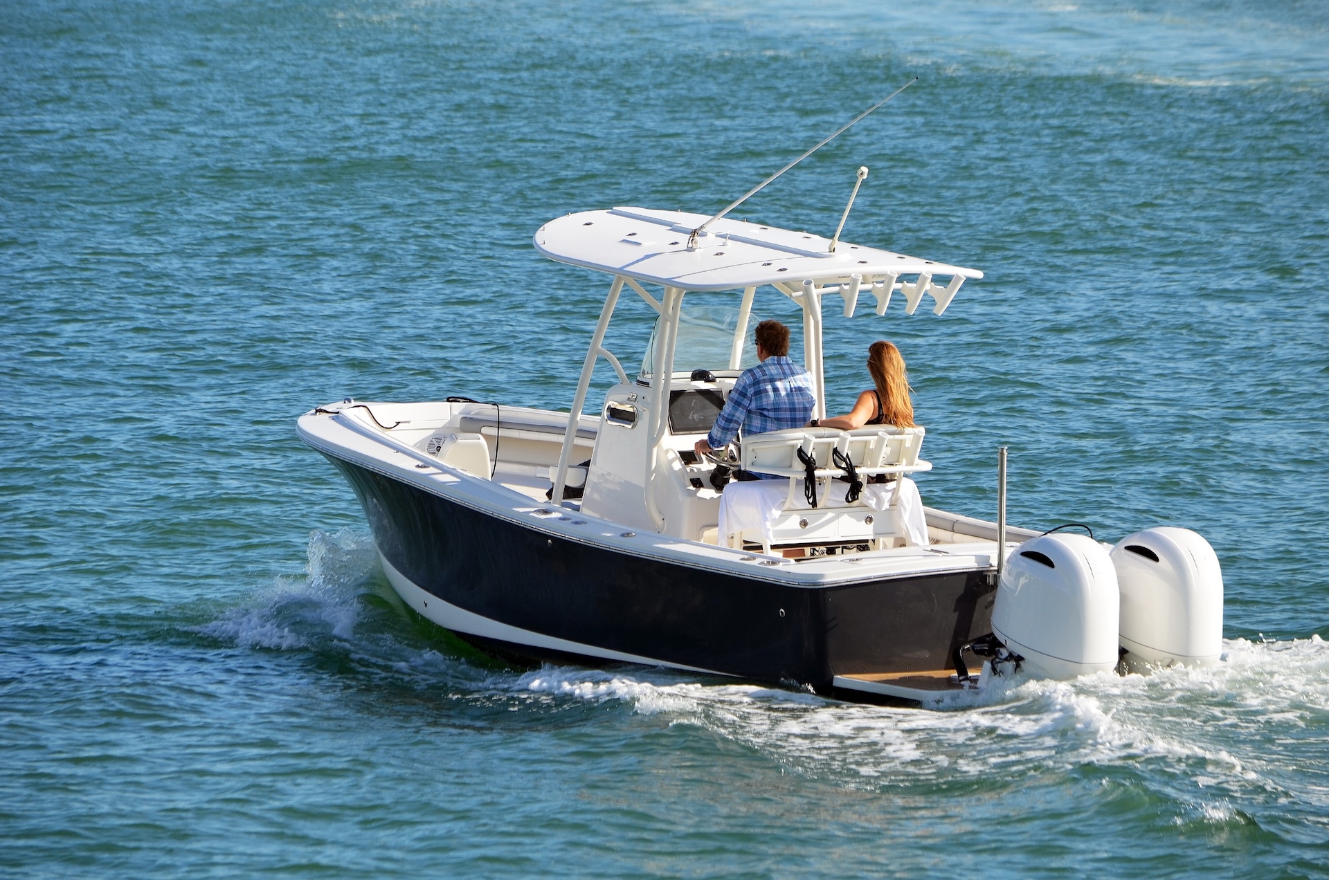 Man and woman on a bay boat, different types of boats concept. 