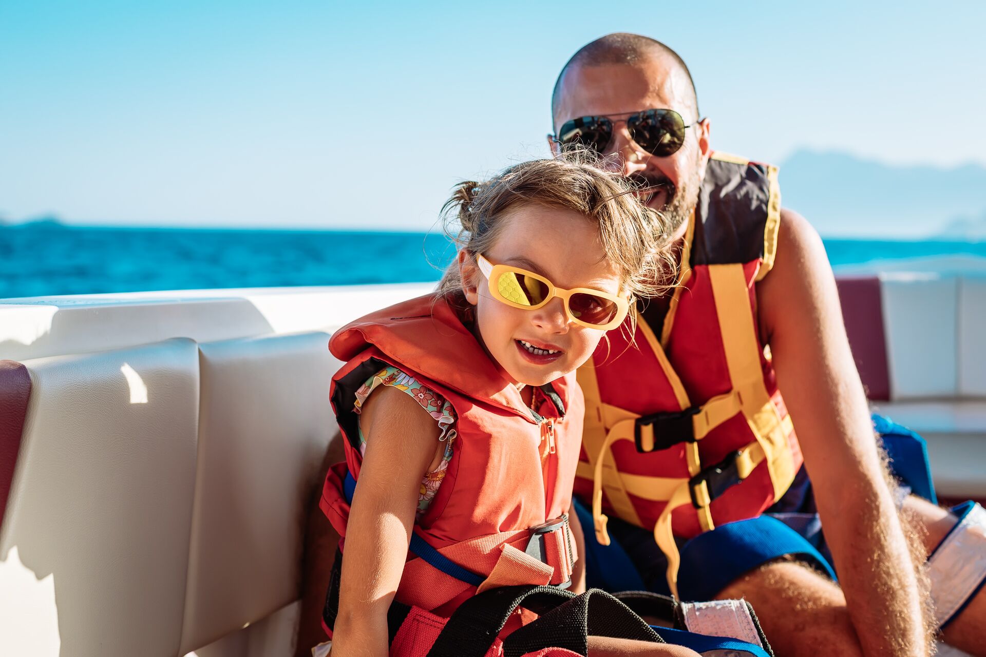 Man and child in lifejackets on a boat, Labor Day boating concept. 