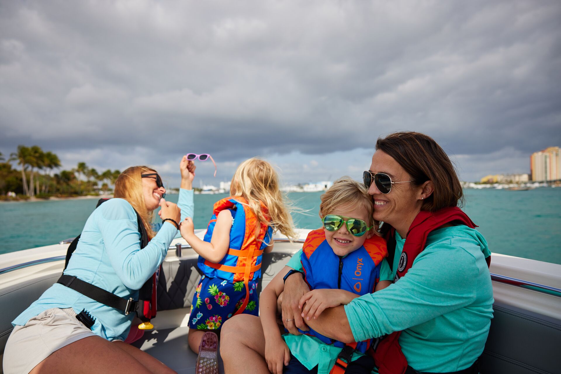 Women and kids in life jackets at front of boat, boating weather forecast concept. 