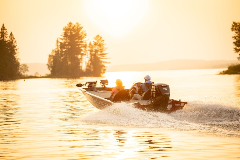 Two people in bass boat head toward shore, learn boating safety tips concept. 