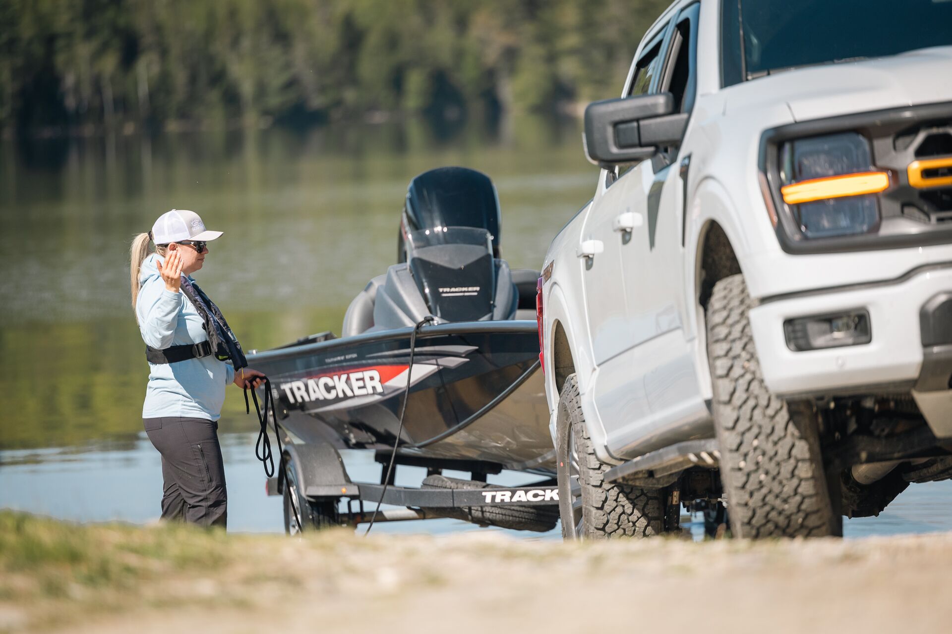 Woman helps truck back boat into water, put boat in water concept.