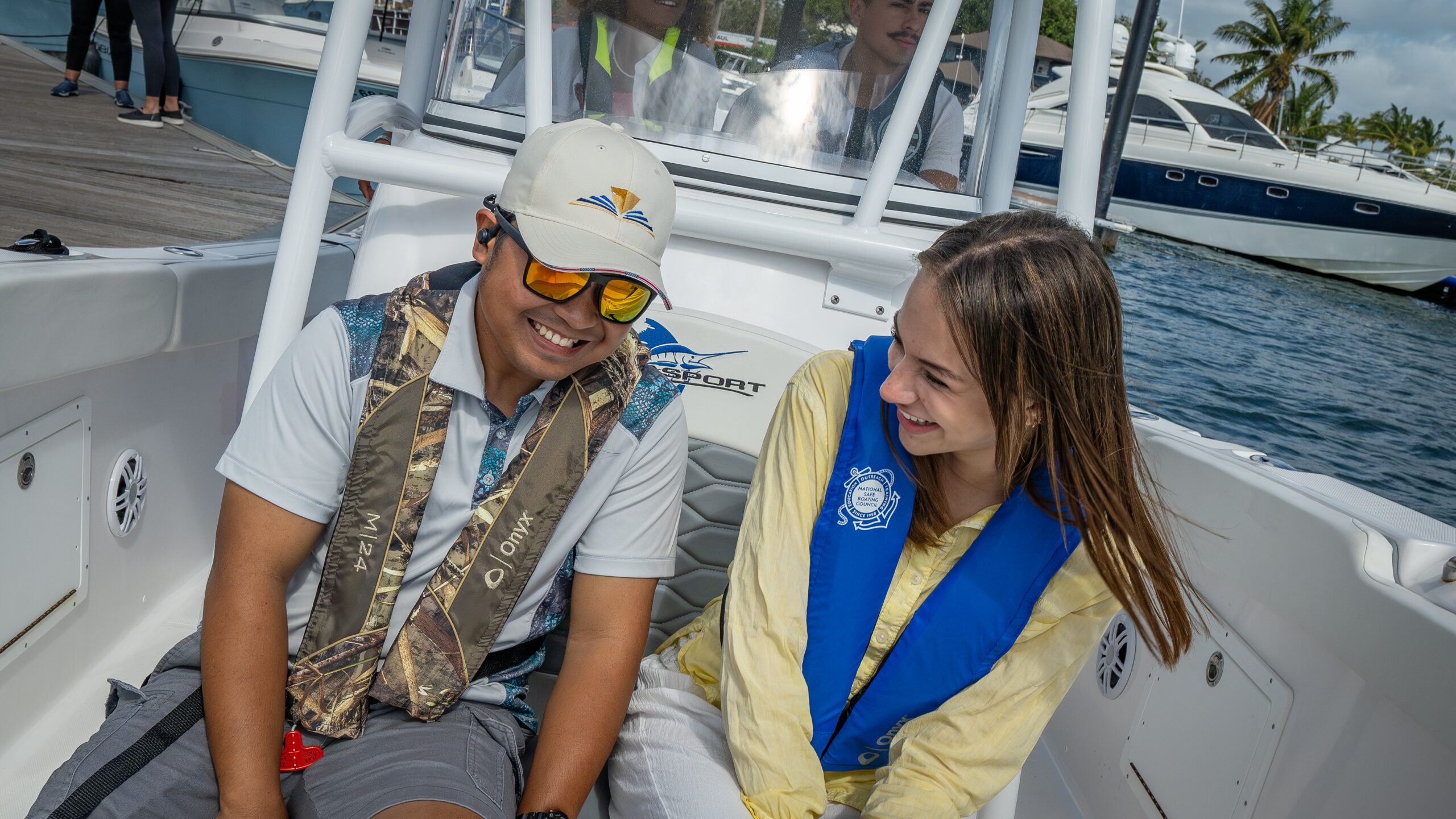 Man and woman on boat wearing inflatable life jackets.