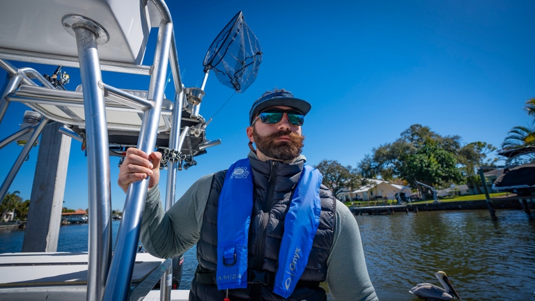 Person on boat wearing inflatable life jacket, best inflatable life jacket concept. 