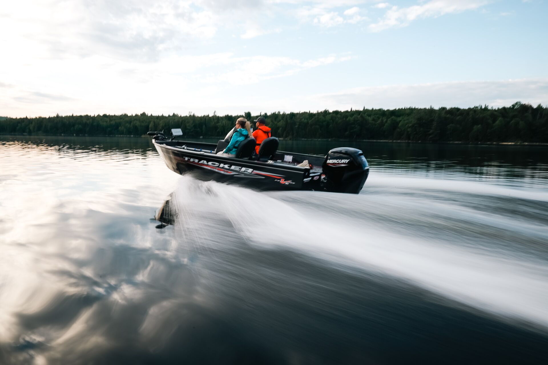 Two people on fast moving black fishing boat,  average cost of boat insurance concept. 