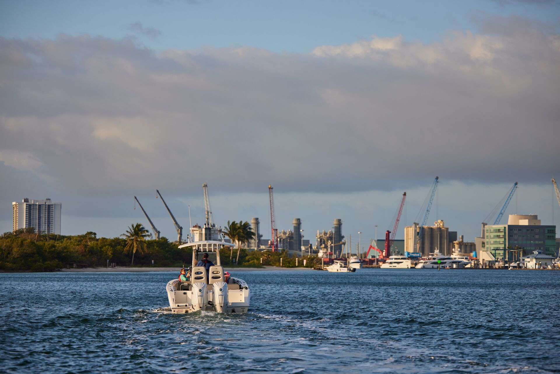 Boat moving toward dark clouds, gale warning concept. 