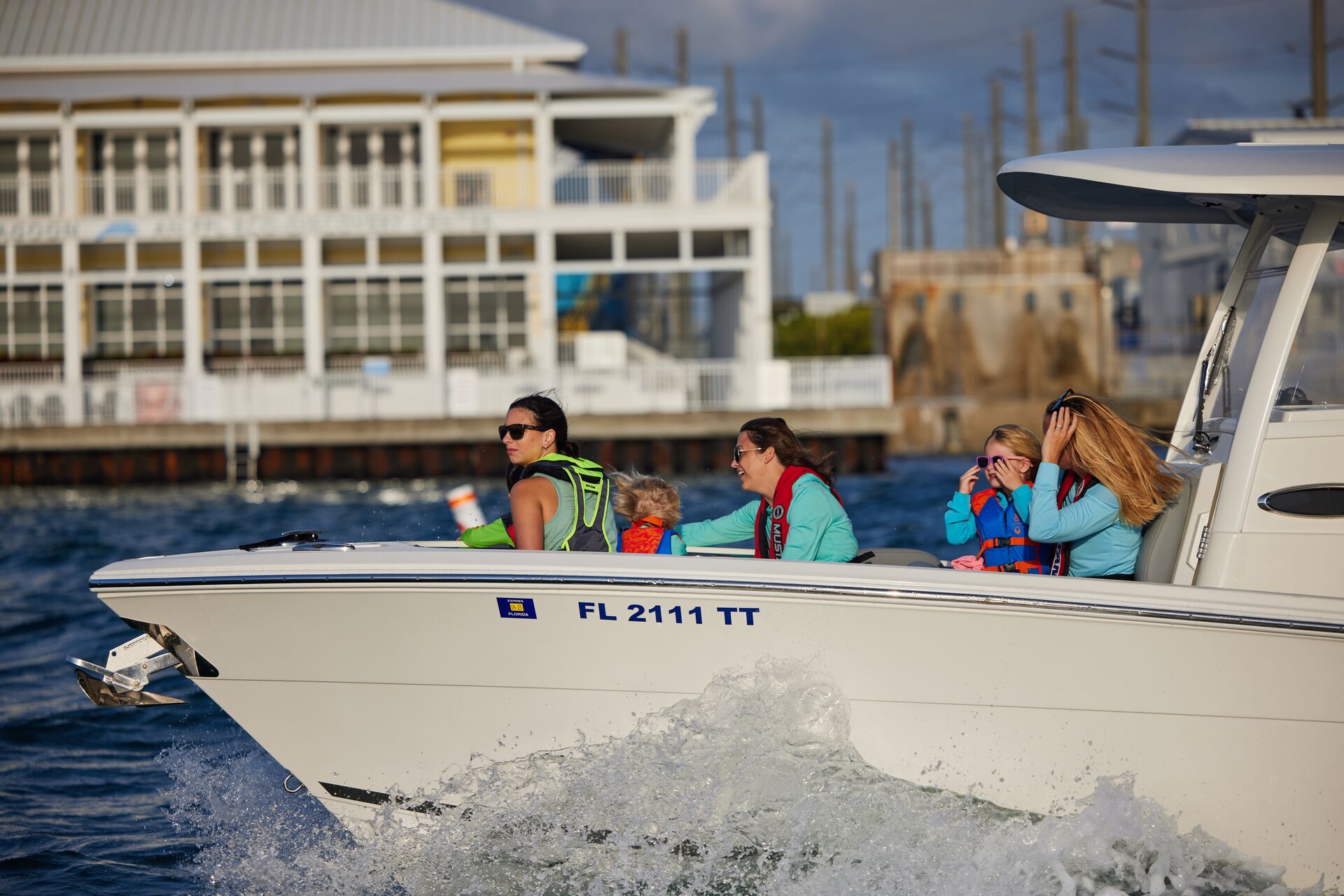 People wearing life jackets at the front of a moving boat, Coast Guard boating laws concept.