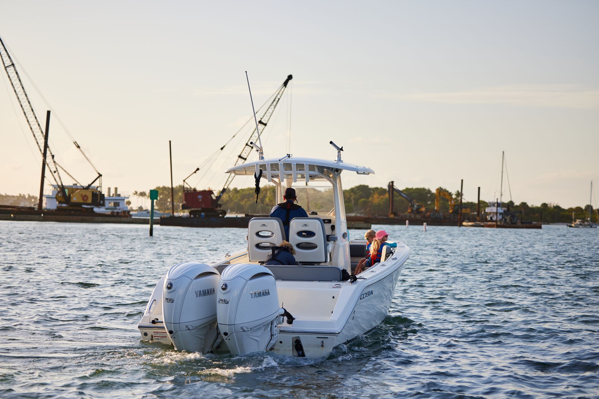 View of back of boat with person driving it away, get a California boating license concept. 