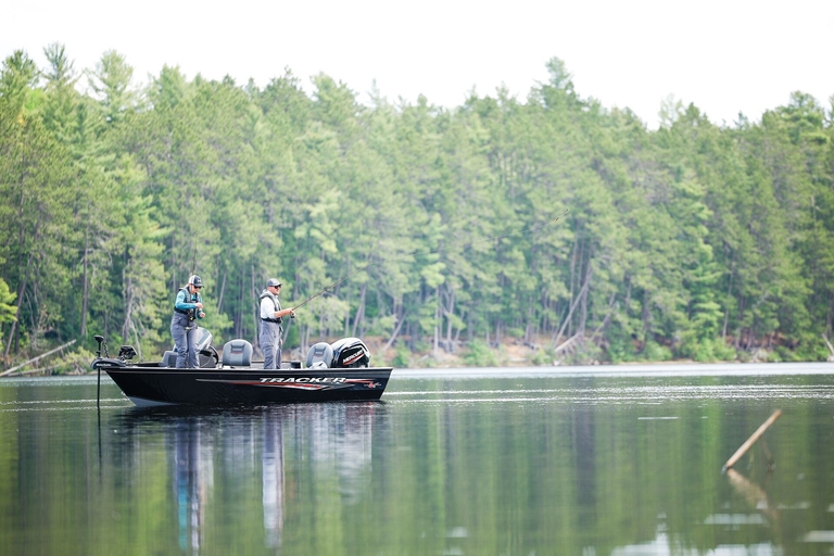 Two people fishing from boat on lake, how to get a boating license in Missouri concept.