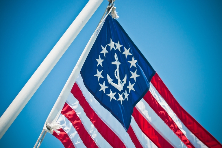 US yacht ensign flag on pole, international maritime signal flags concept.