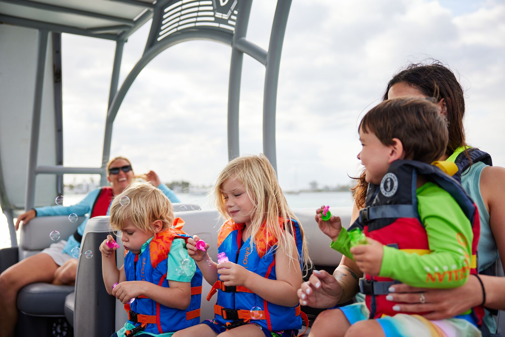 Kids and adults in life jackets on a boat, get an Arizona boating license concept.