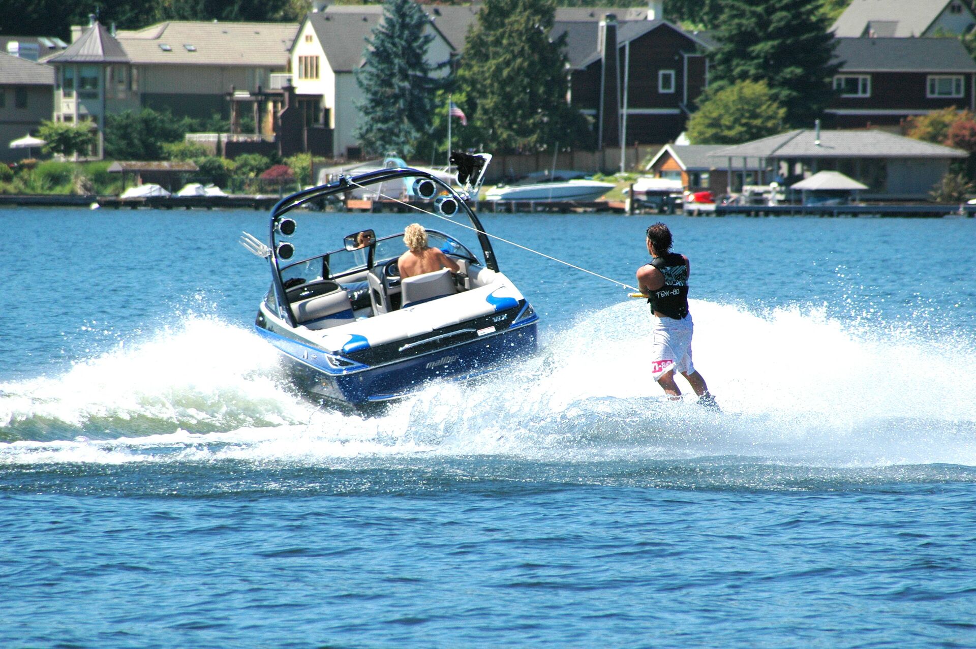 Boat pulling a person on jet skis, how to register a boat in Iowa concept. 