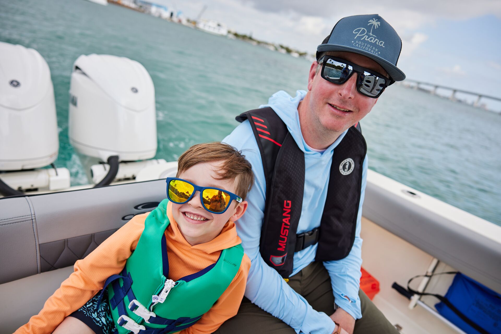 Man and boy in life jackets on a boat. 