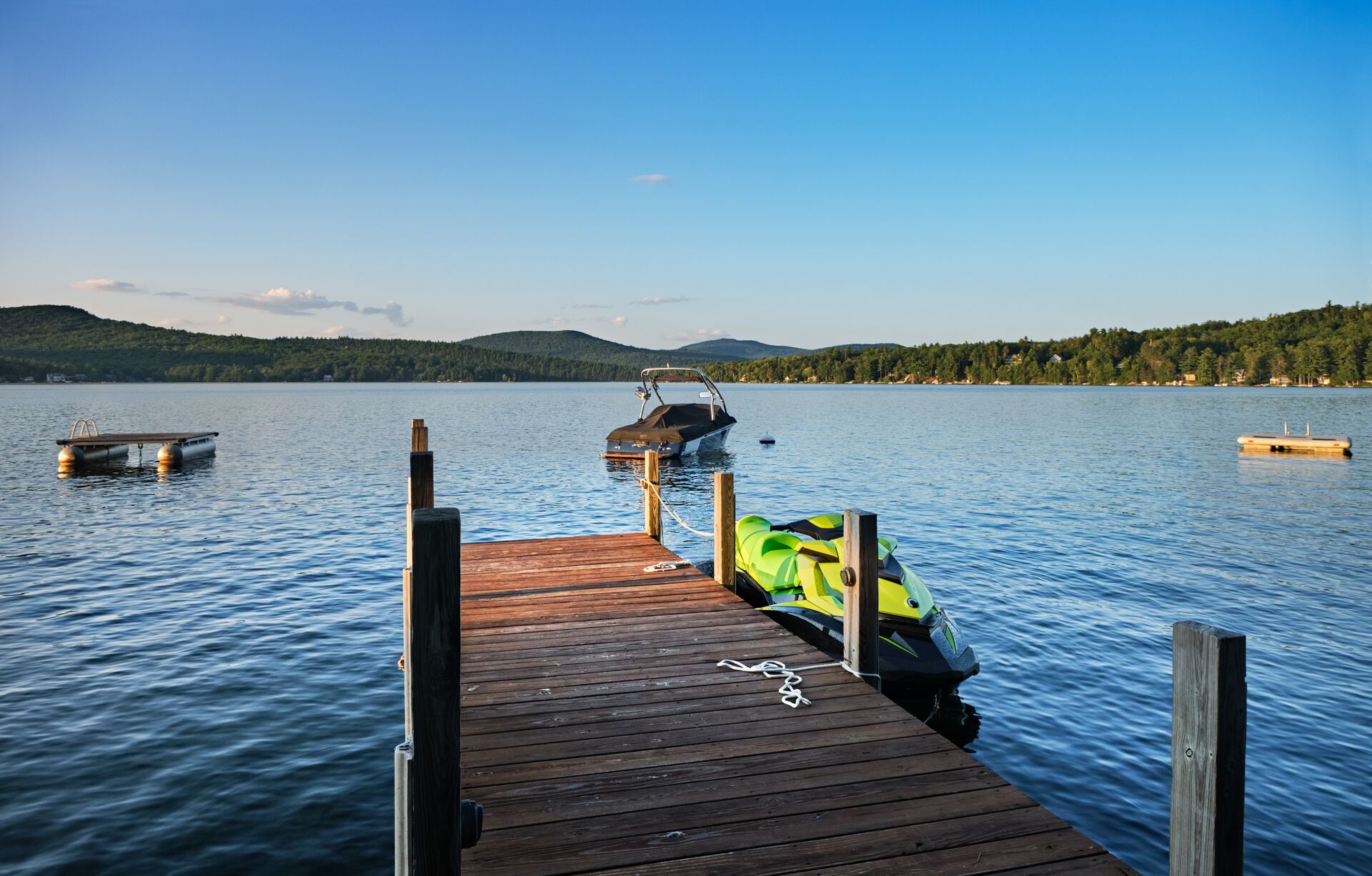 Boat and PWC near dock on a lake. 