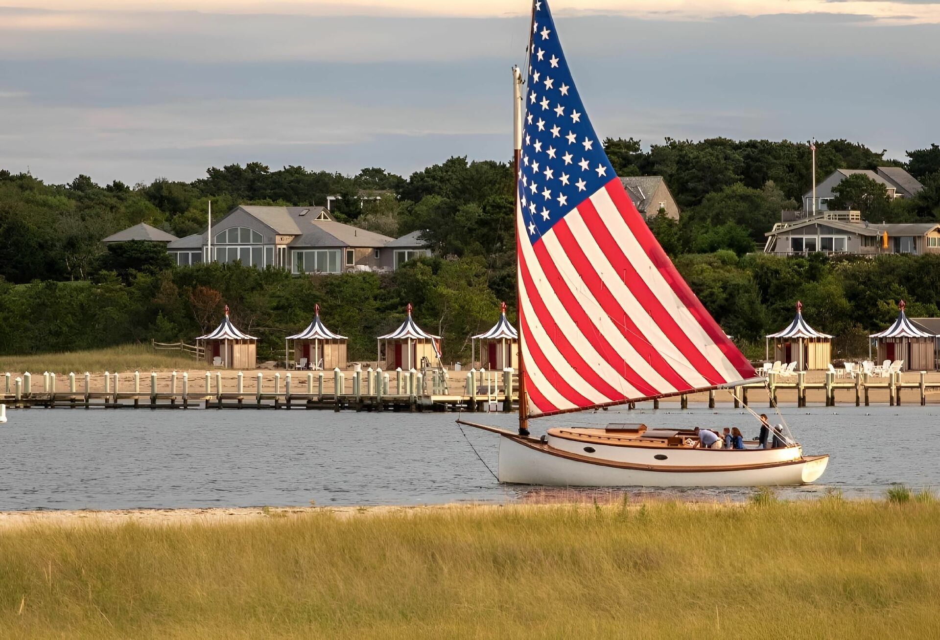 Sailboat on water with large American flag sail, how to get a boating license in New York concept. 