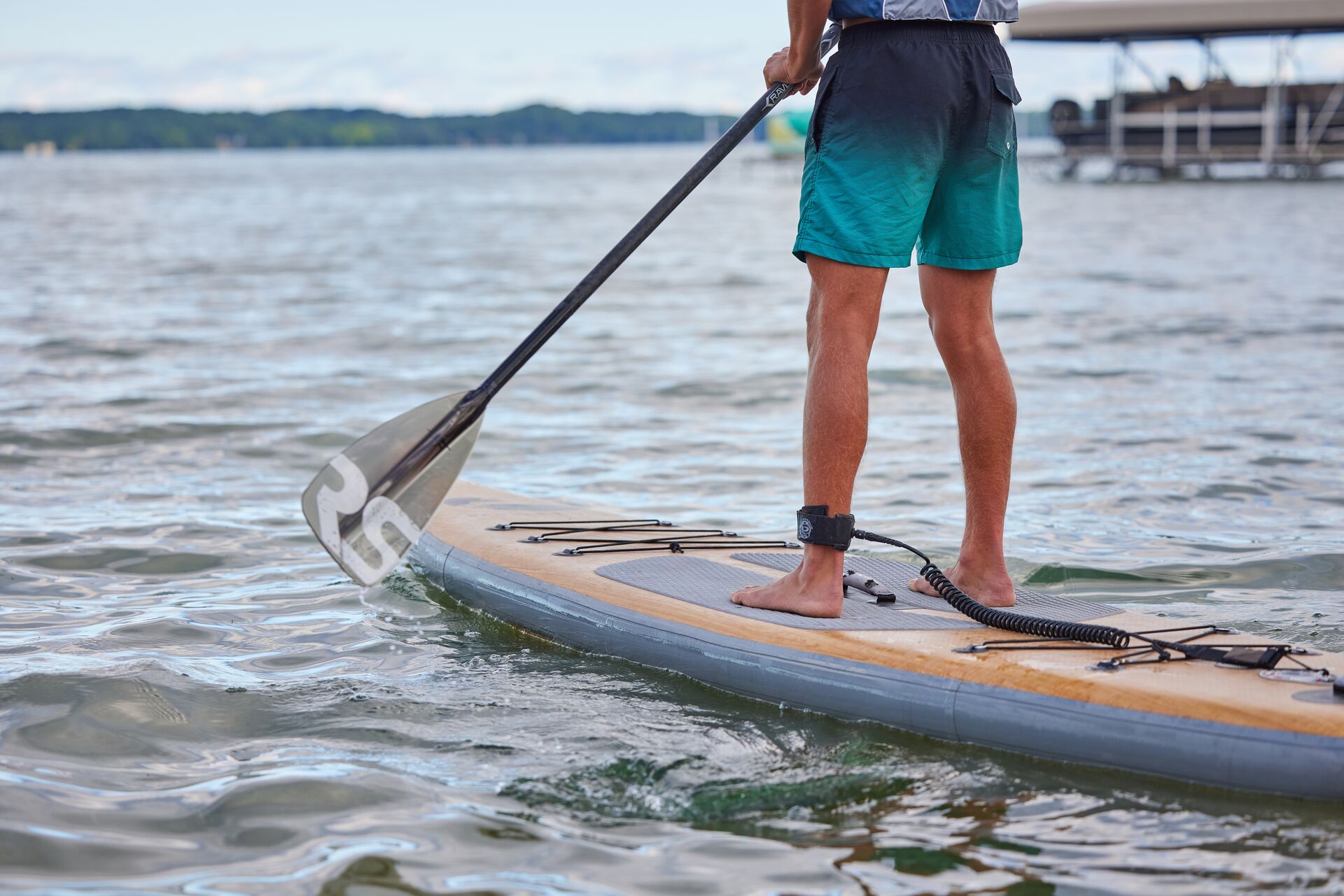Close-up of legs of someone on a paddleboard. 