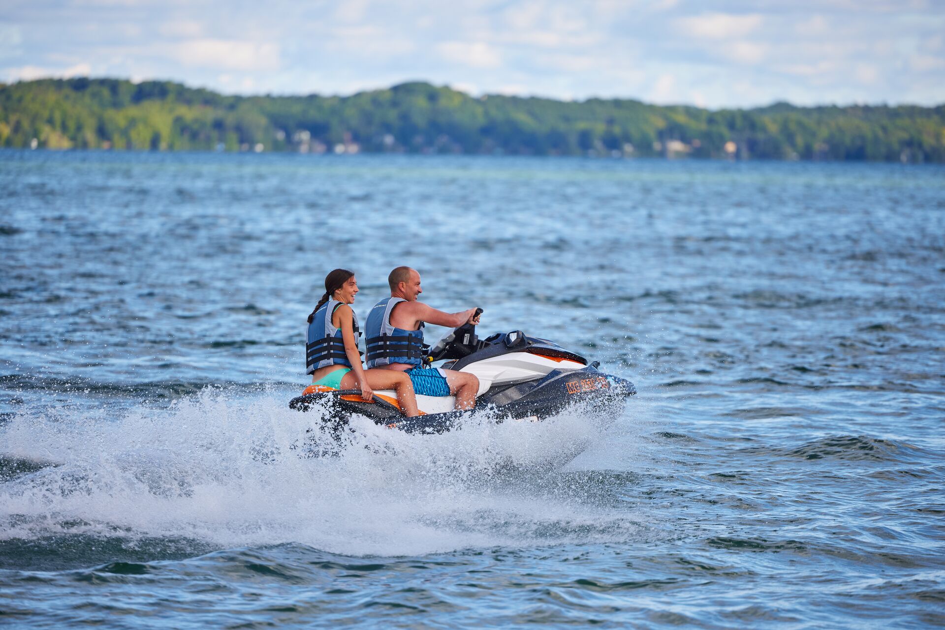 Girl and man riding a jet ski on the water. 