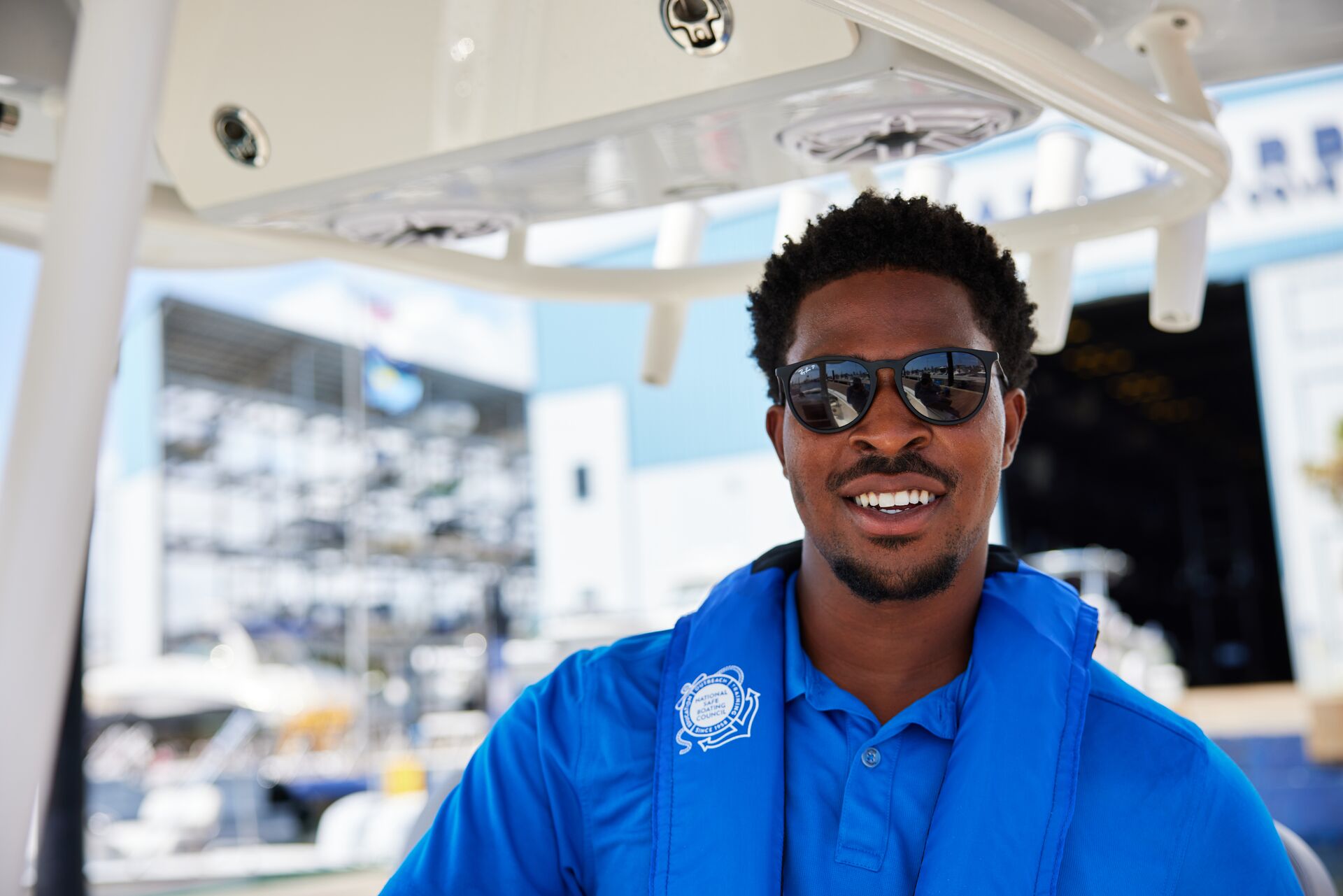 Smiling man in blue life vest, how to get a boating license in Wisconsin concept. 