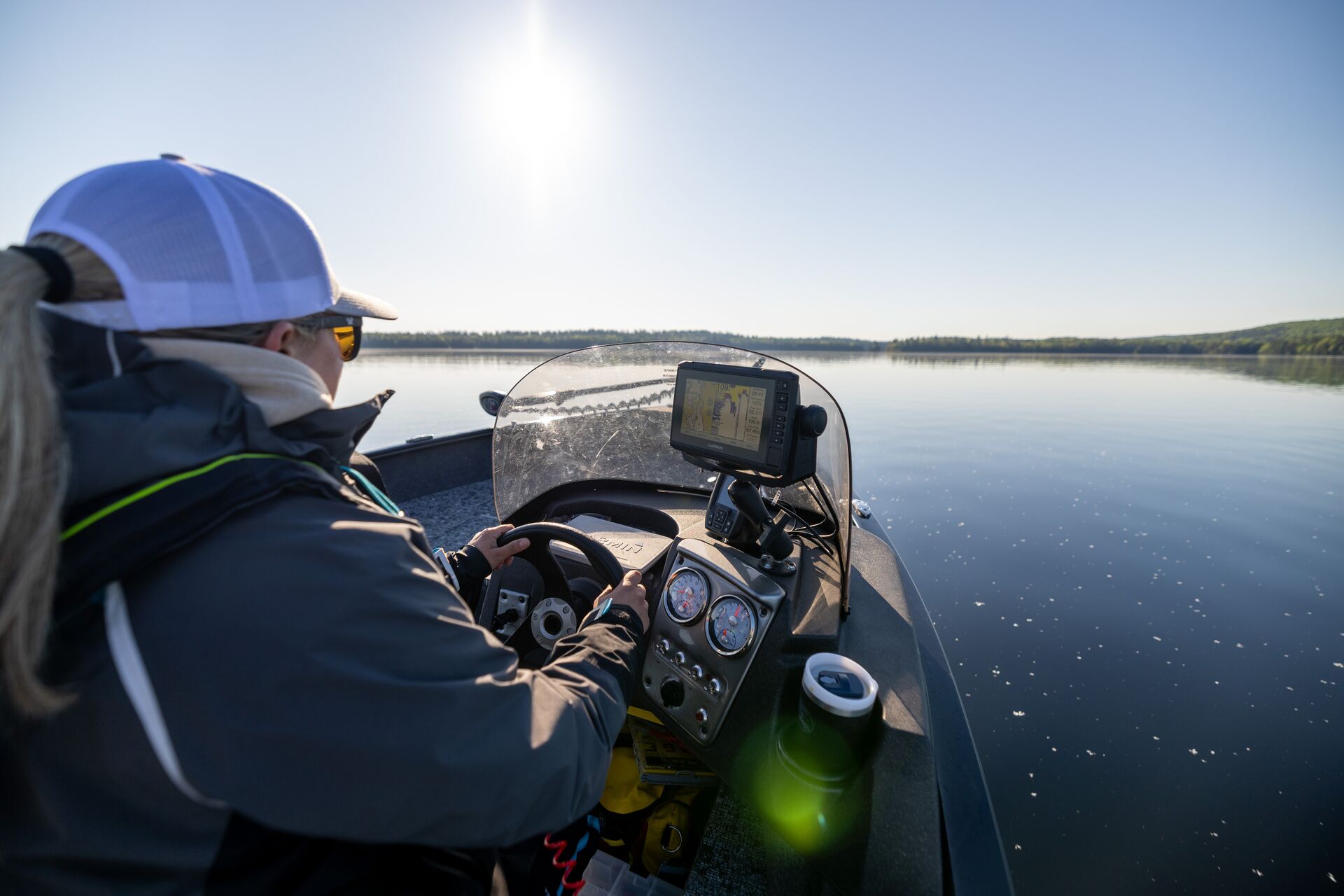 View of the shoulder of woman driving boat, do you need a boating license in Kentucky concept.