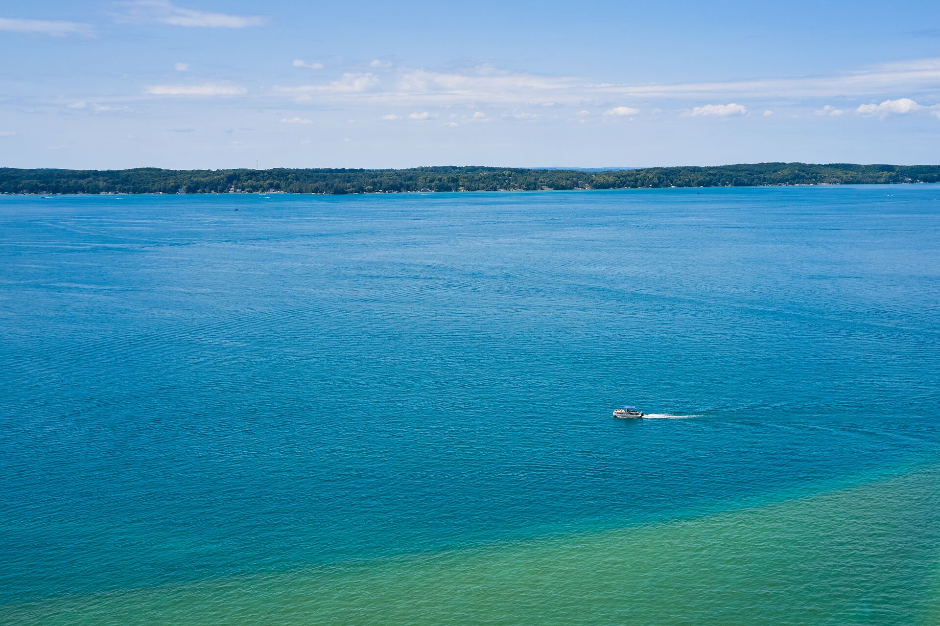 Aerial view of a boat on a big lake, do you need a boating license in Tennessee concept.