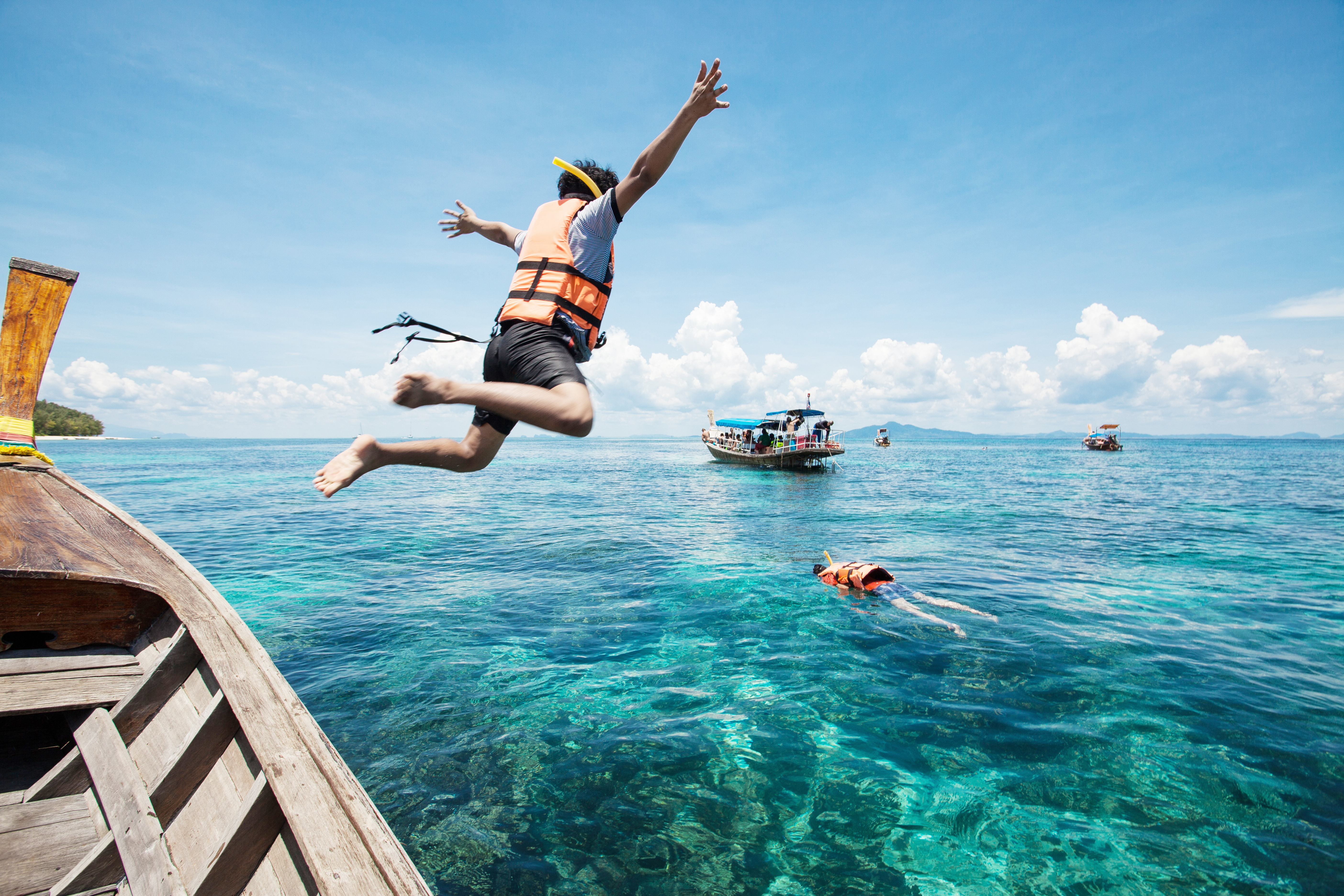 A person wearing a lifejacket jumping into the water, drowning prevention concept. 