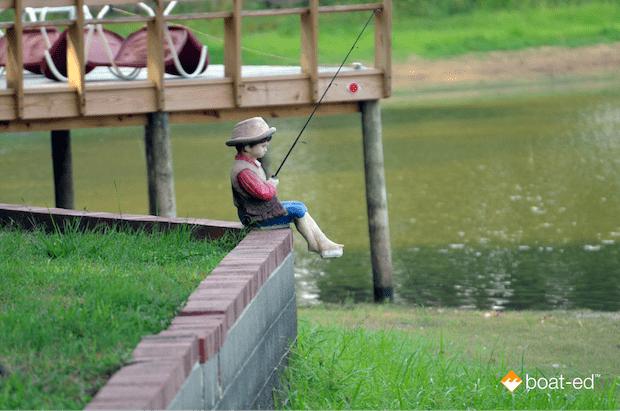 A statue of a boy fishing sitting on top of a wall, how to get a fishing license concept. 