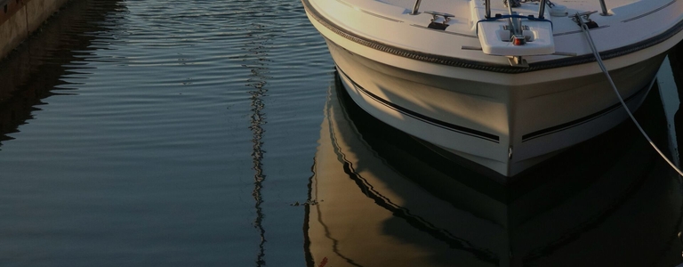 Boat hull on calm water, Boat-Ed vs BoatUS boating course concept.