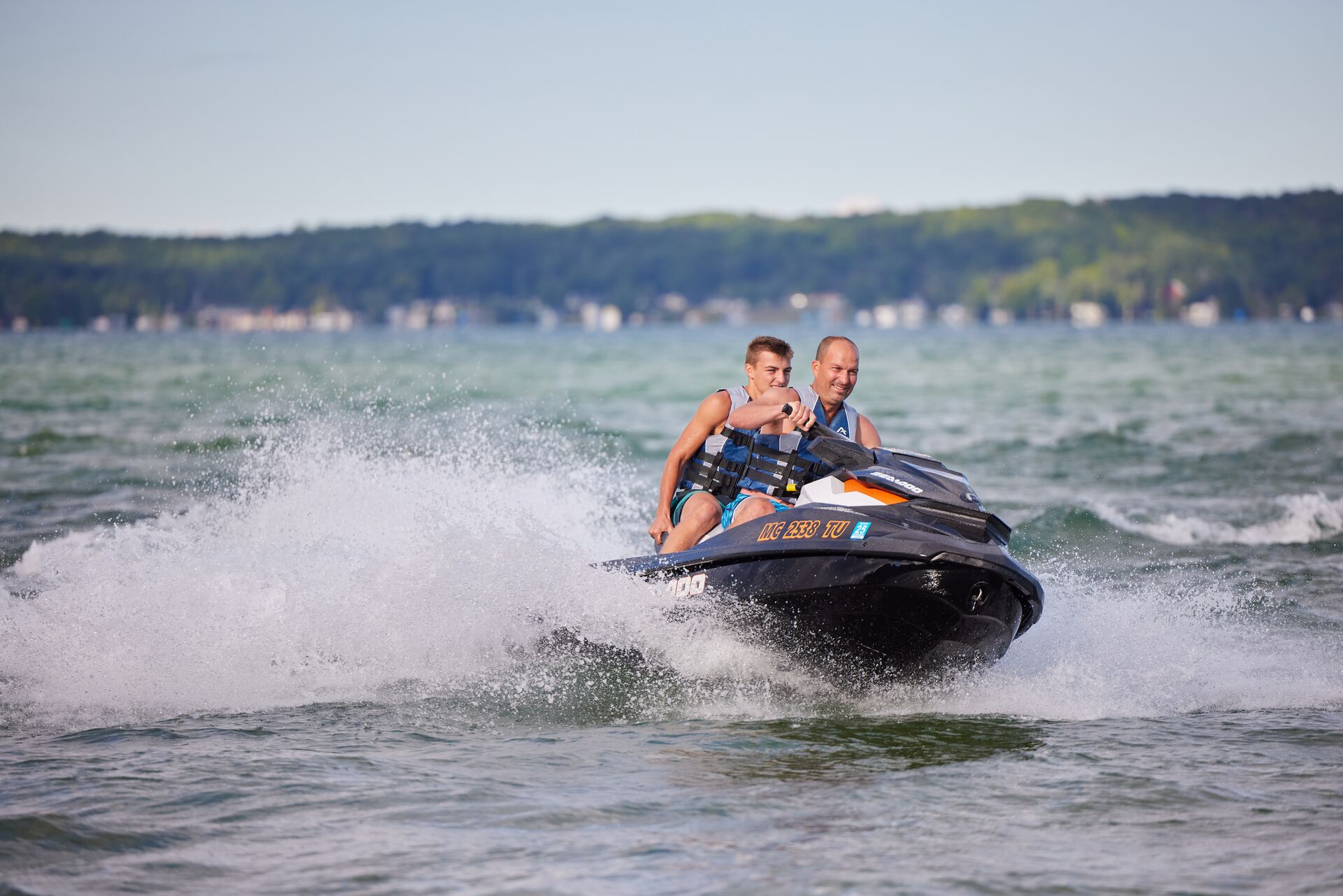 Man and boy ride PWC, boater education card boat rental concept.