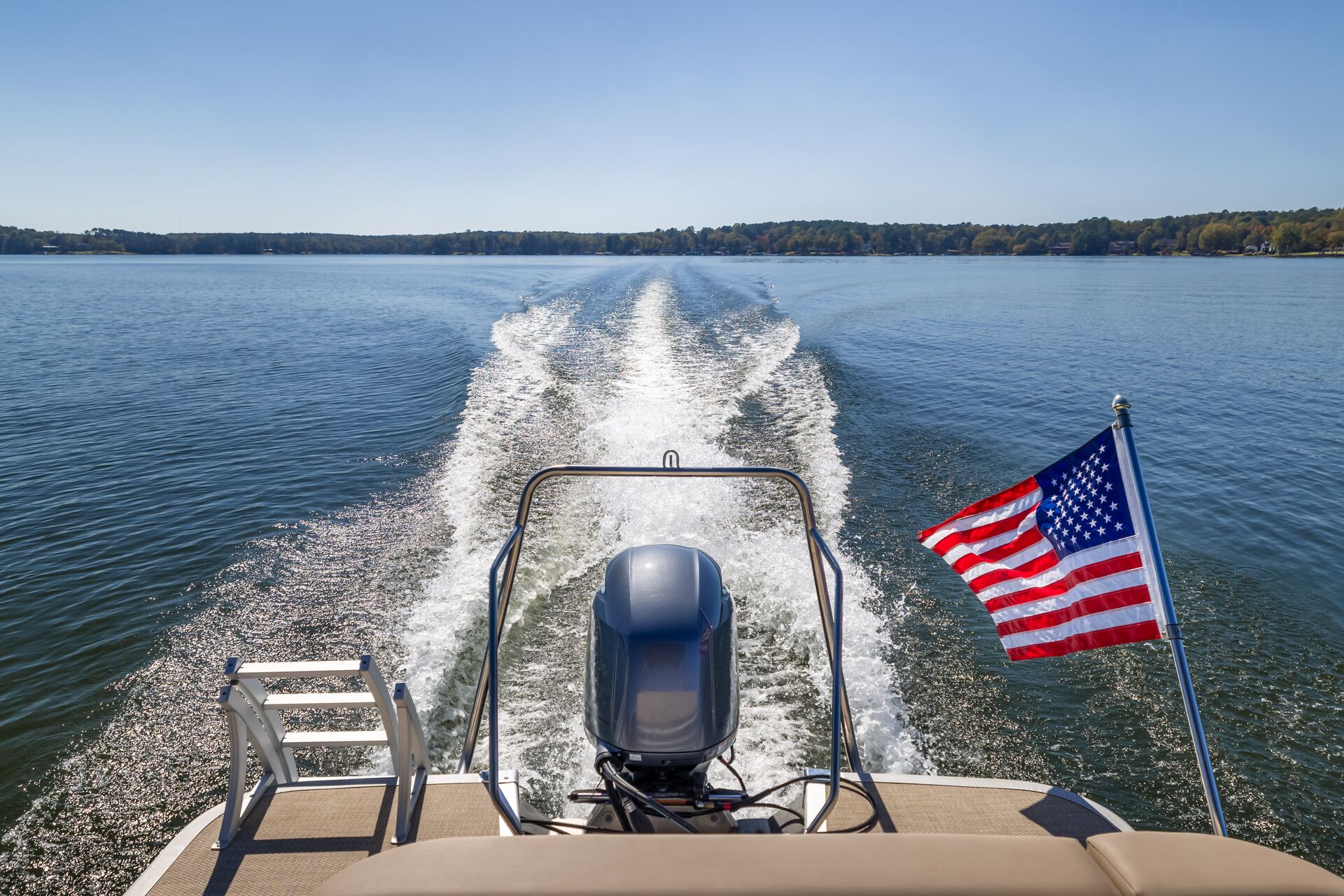 Wake and back of boat with US flag, fine for boating without a boater education card concept. 