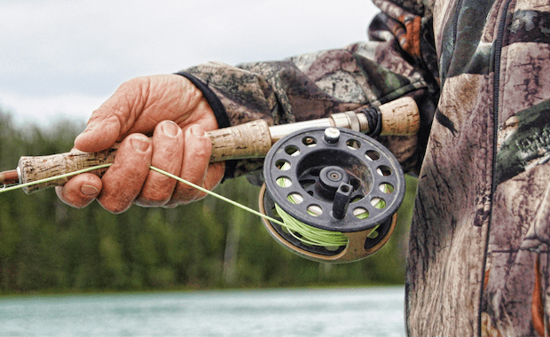 Close-up of someone holding a fishing rod and reel, go fishing concept. 