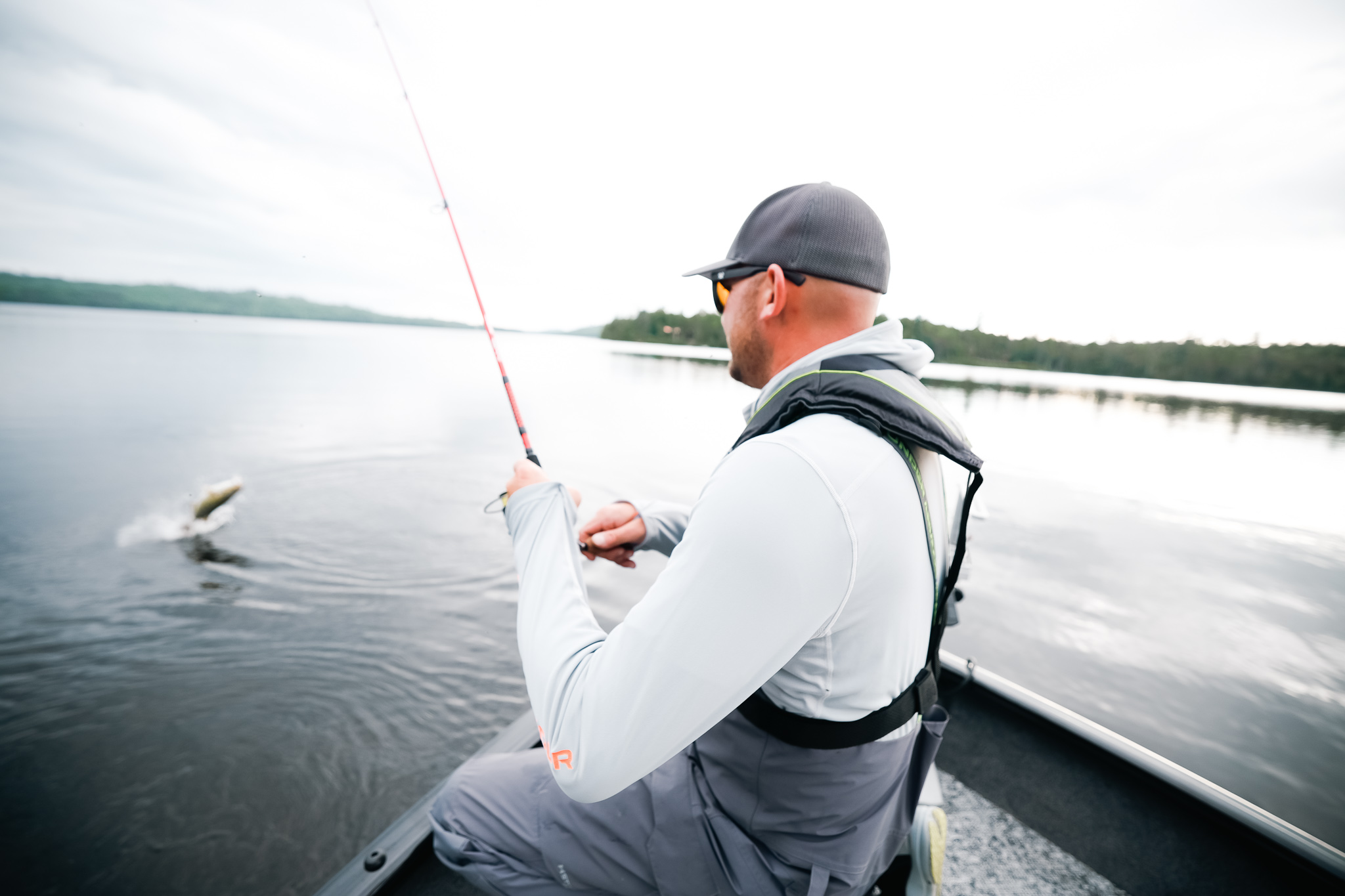 Angler on a boat reels in a fish, go fishing concept. 