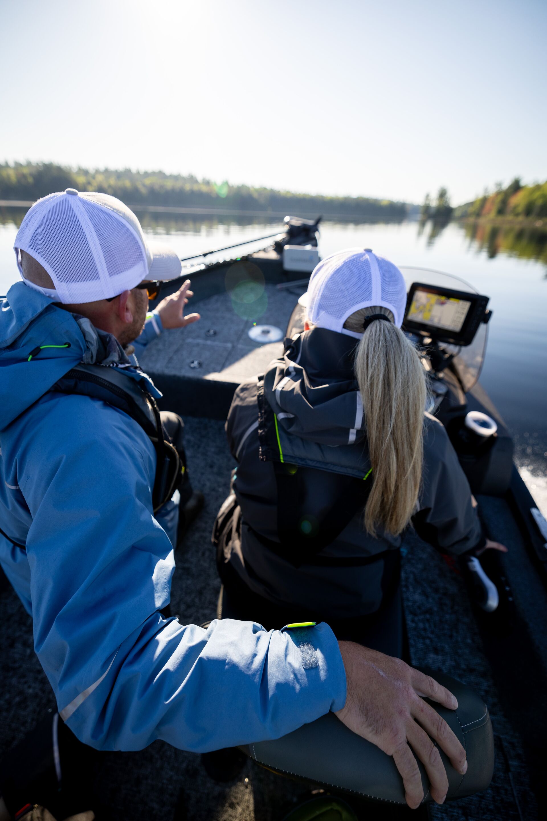 Man showing woman how to drive boat, how long does it take to get a boating license concept. 