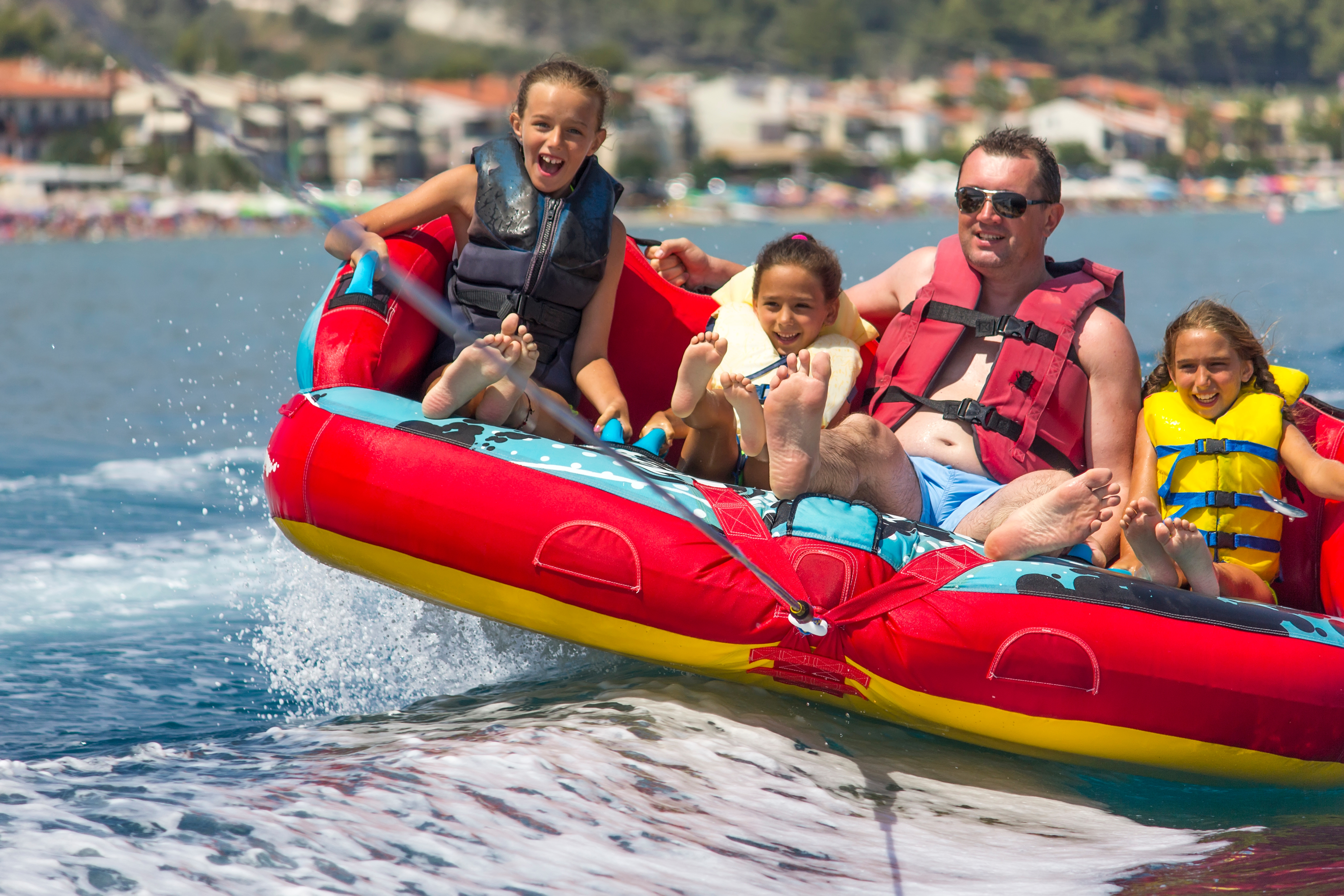 Family in lifejackets pulled on tube on water, boating safety checklist concept.