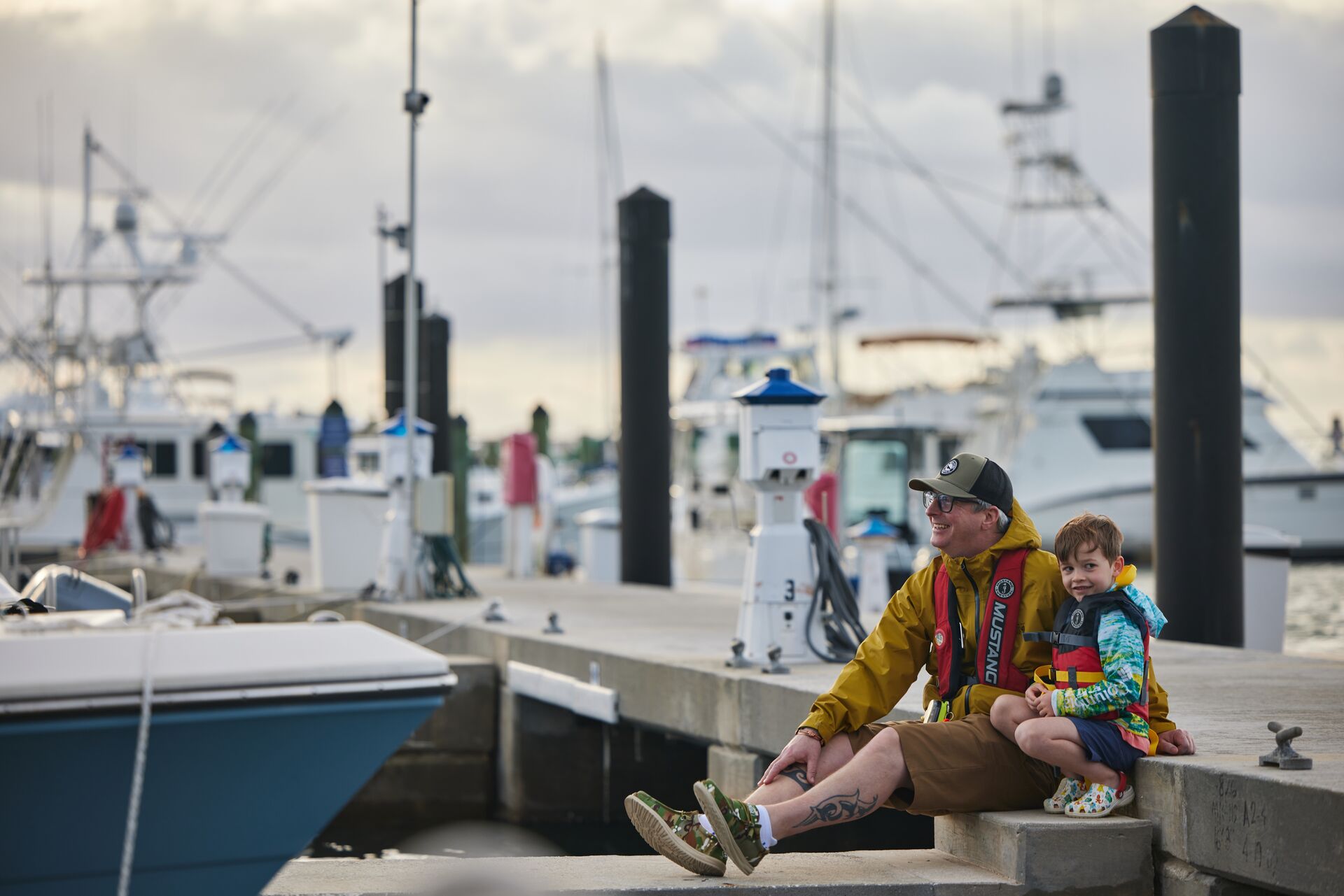 Man and boy in lifejackets on dock, how many life jackets required on boat concept.
