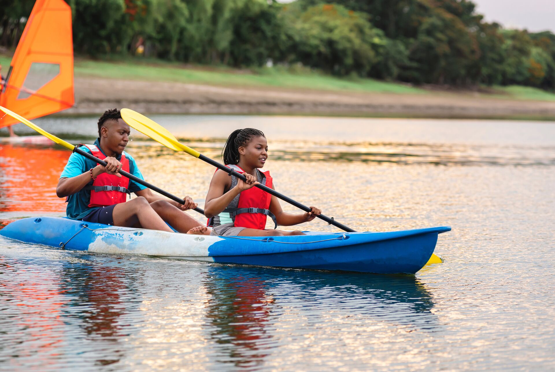 Two people wearing lifejackets in kayak, how many lifejackets do I need concept. 