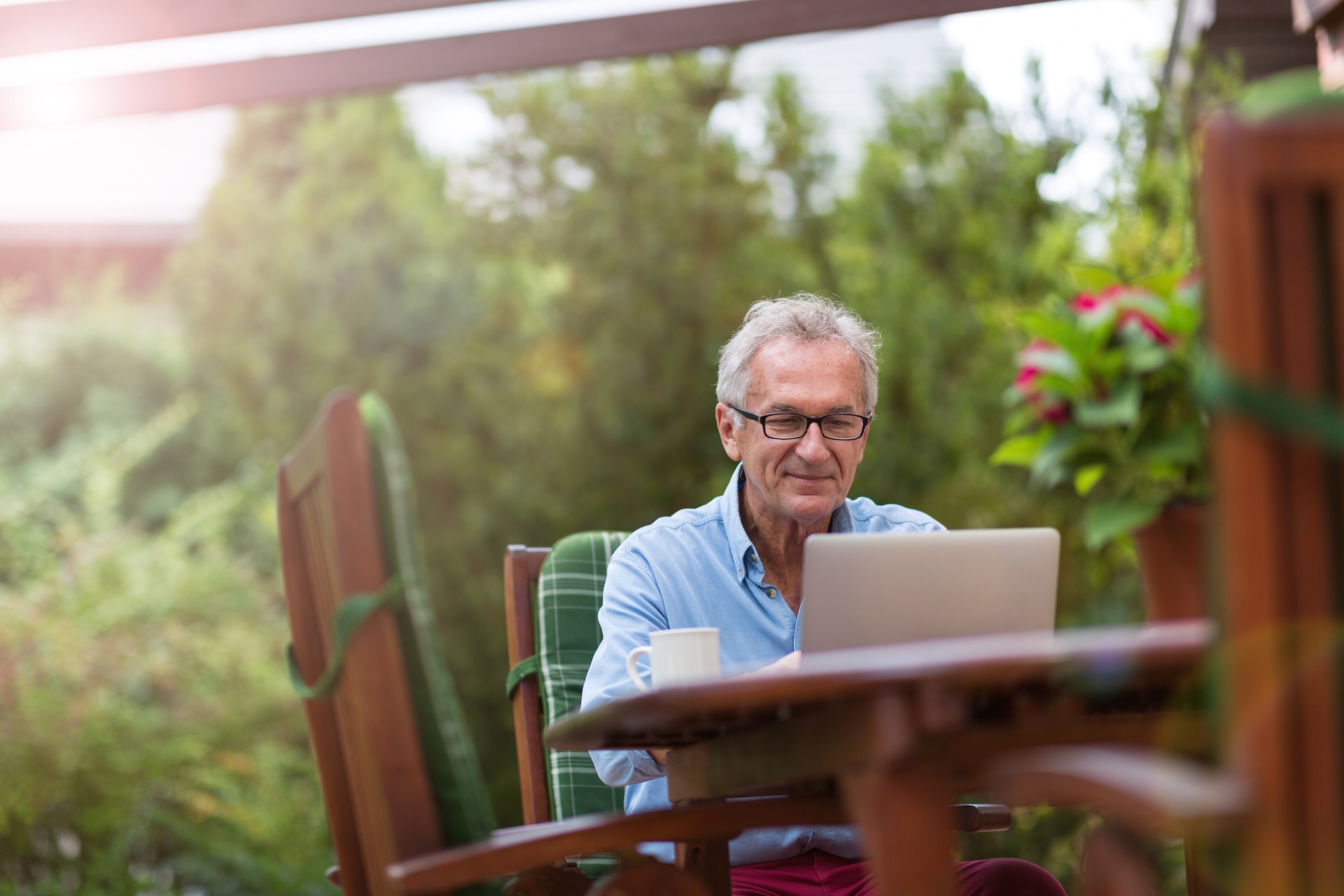 Man sits at a table to use laptop, how to pass boating safety exam concept. 