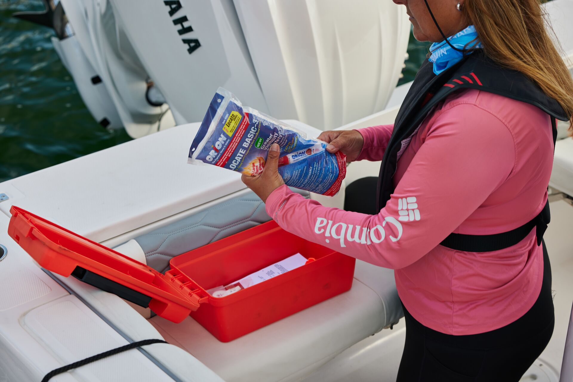 Woman with flare and emergency box on boat, boating safety course study tips concept. 