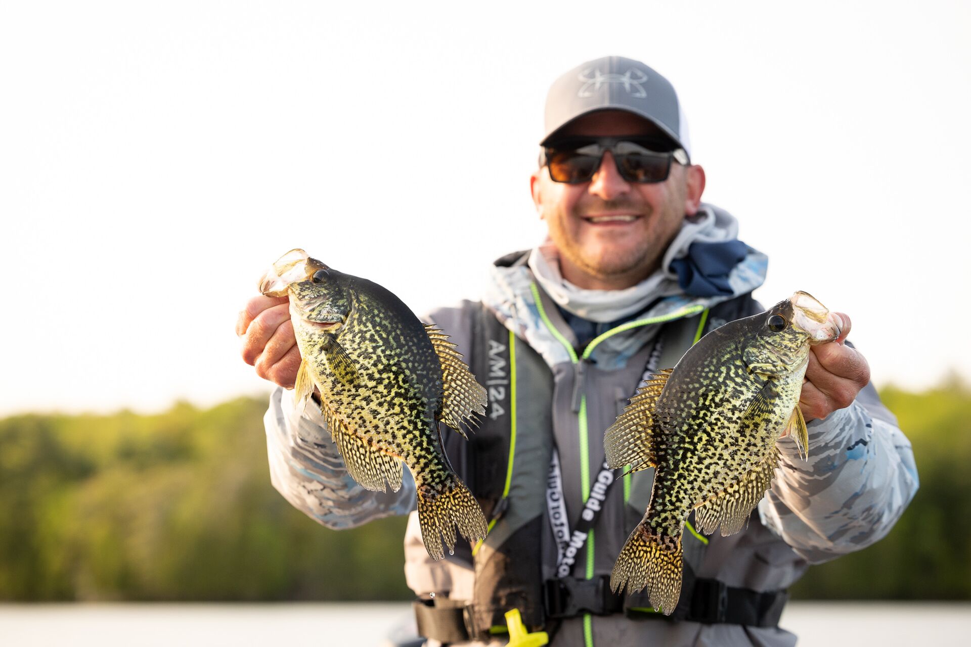 Man holds two fish, know boating license fishing requirement concept.