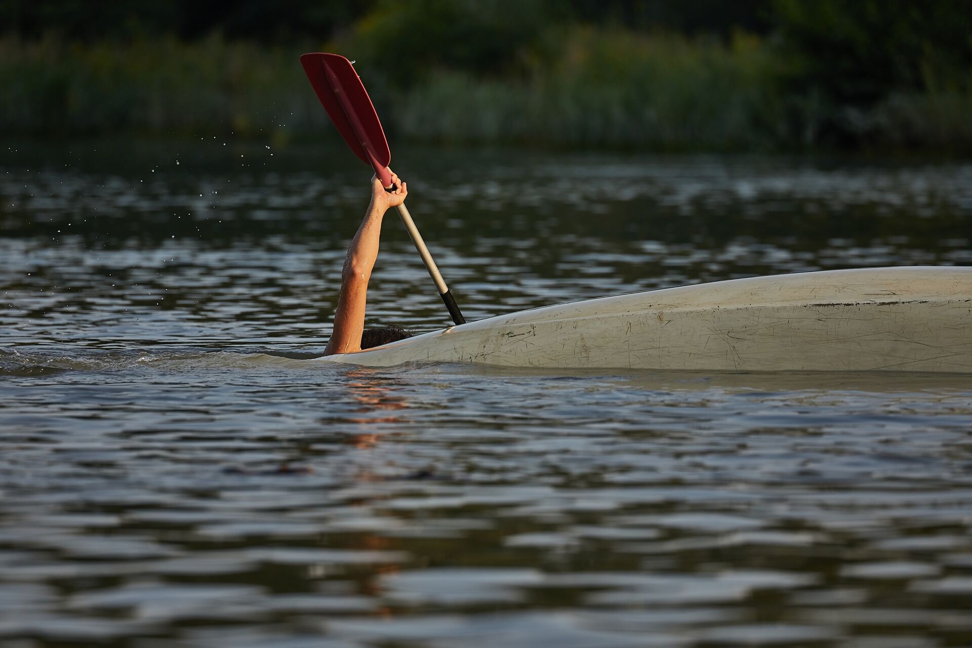Person in the water near canoe, how to treat hypothermia on a boat concept. 