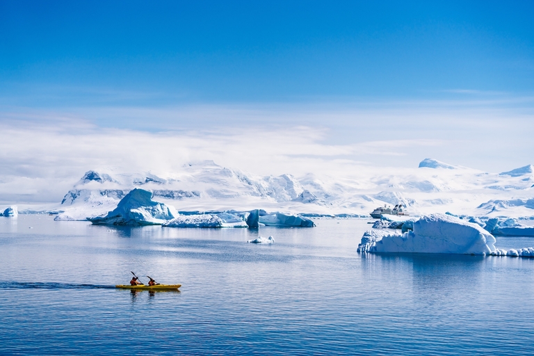 Two people kayaking near icebergs, how to treat hypothermia on a boat concept.