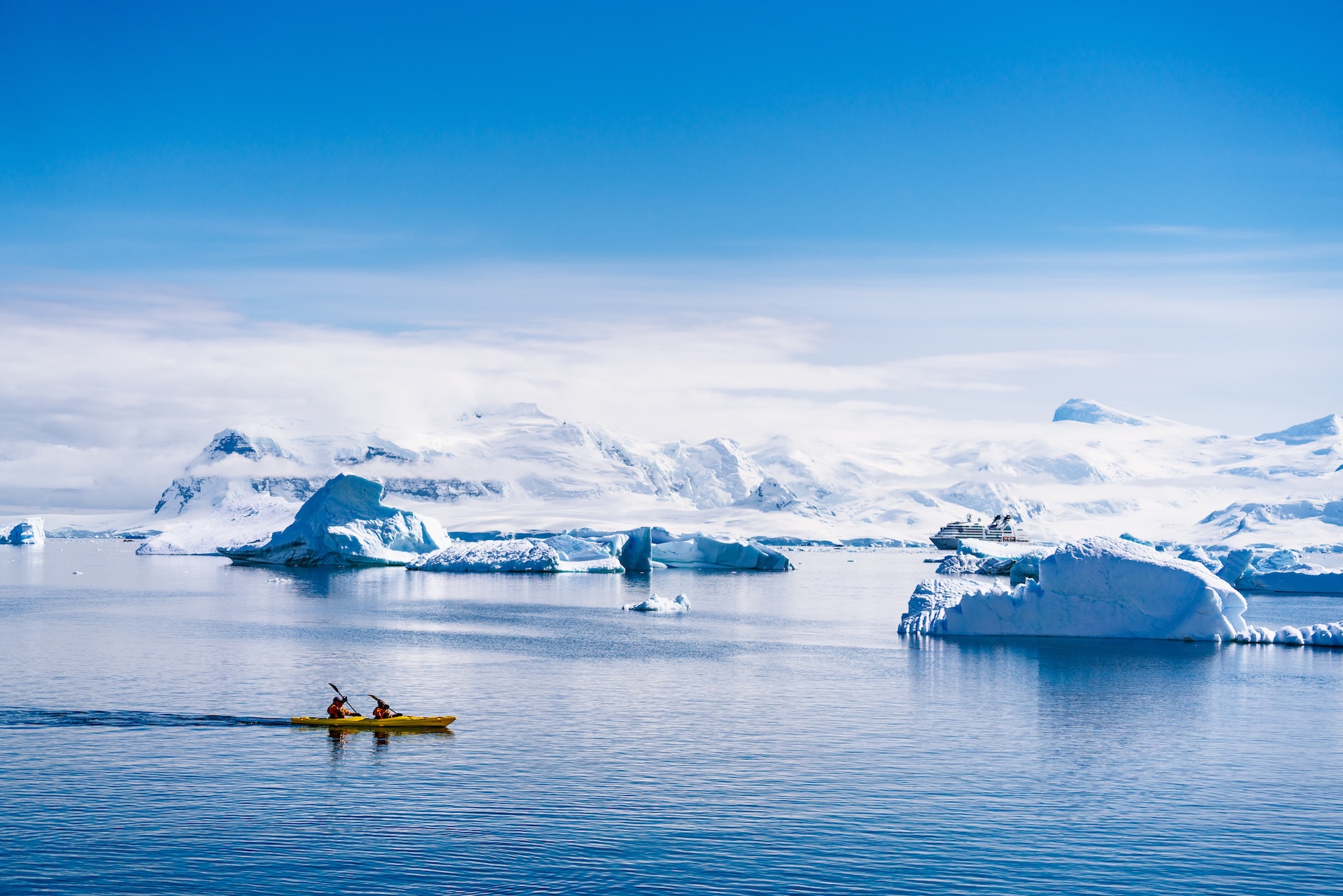 Two people kayaking near icebergs, how to treat hypothermia on a boat concept.