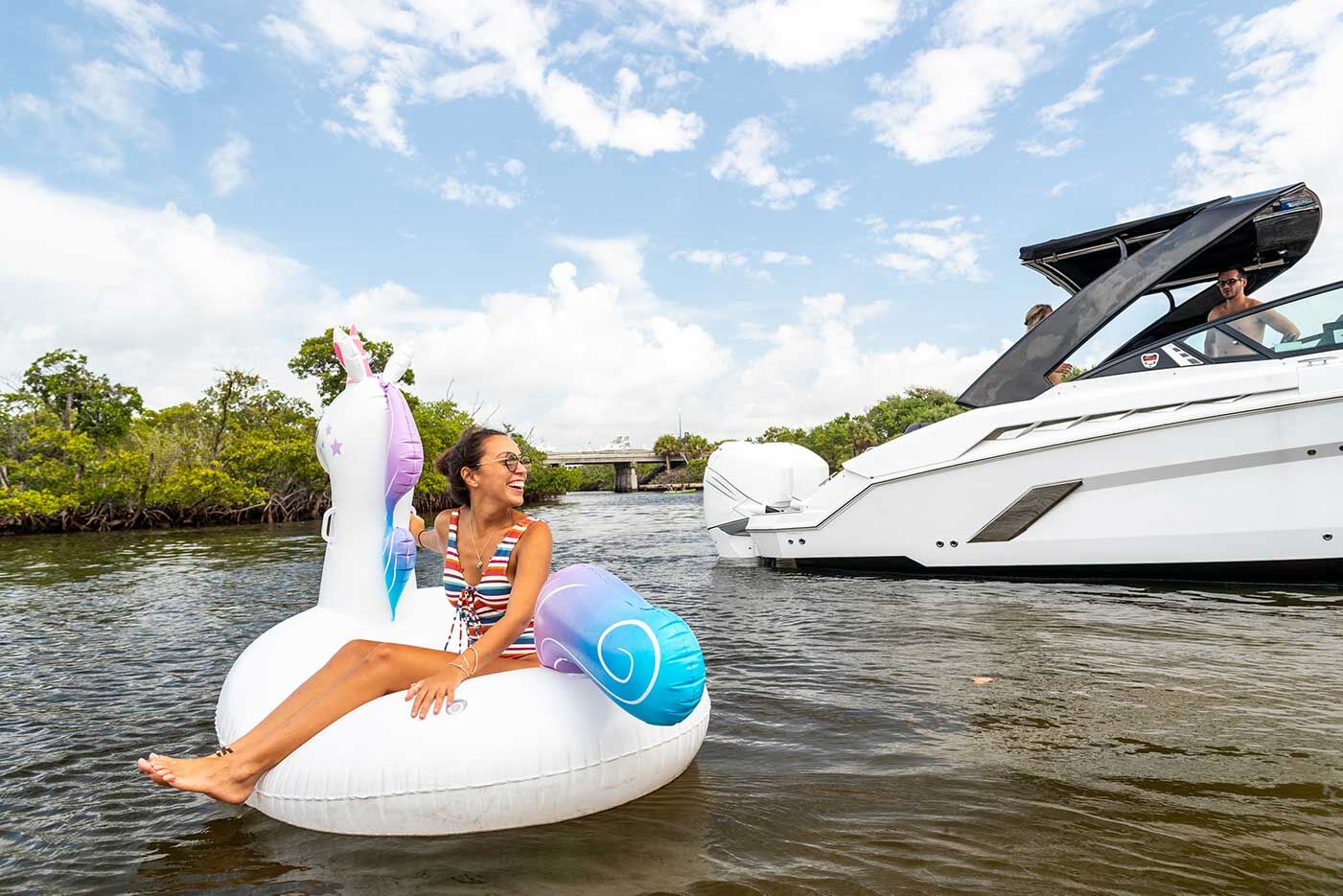 Girl on inflatable unicorn next to boat, rent a boat in New York concept.