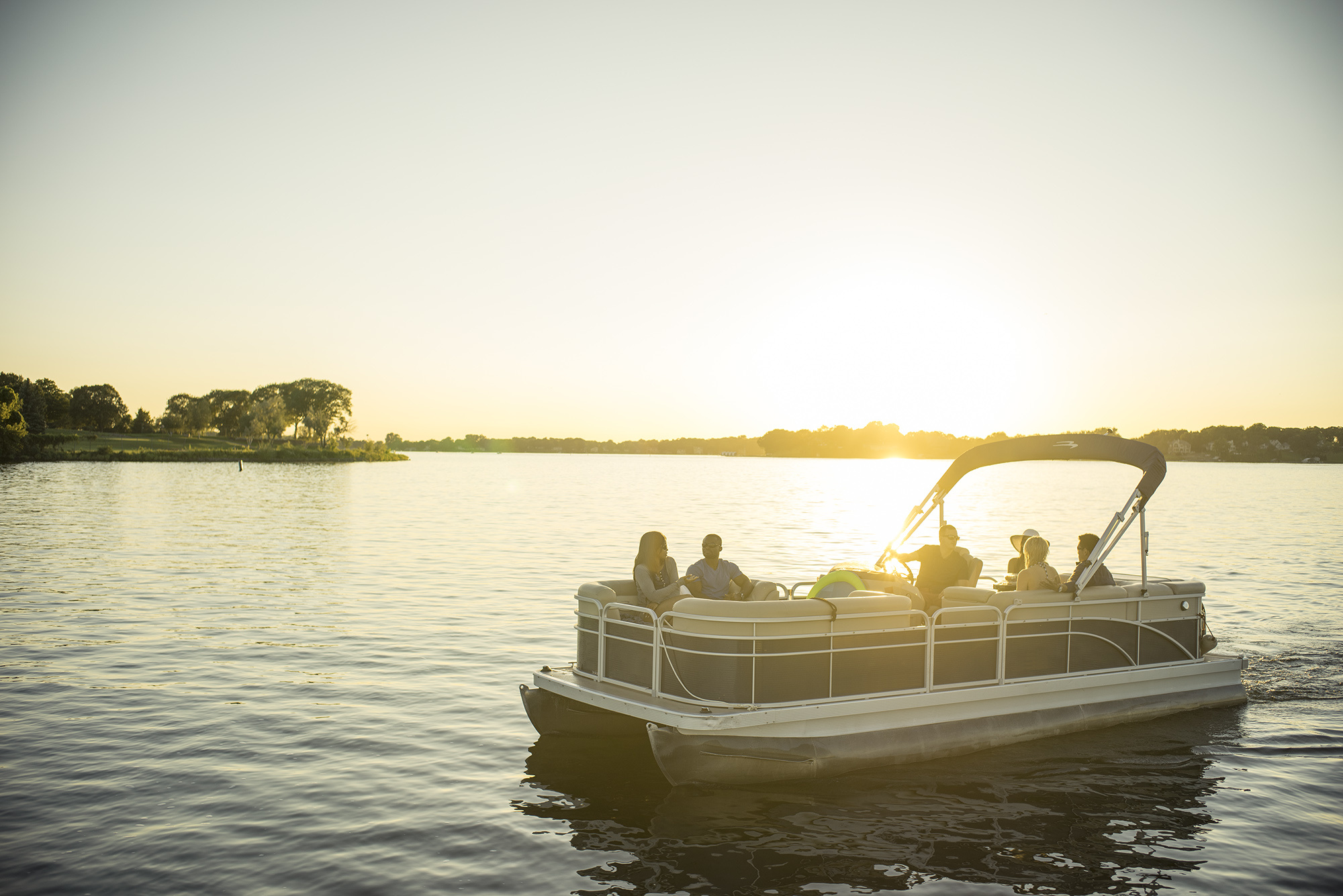 People on a pontoon boat on the water, avoid Florida boating violations concept.