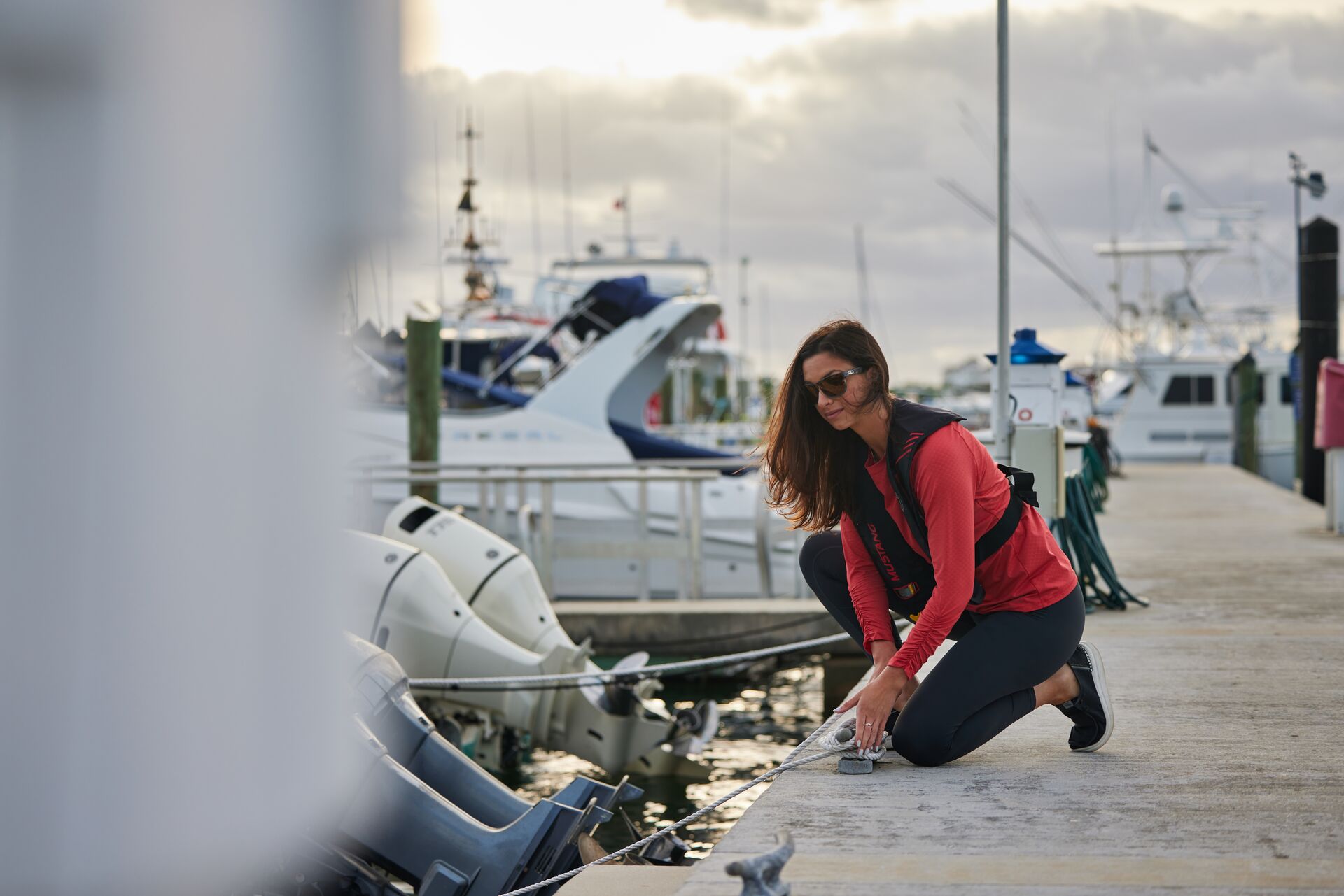 Woman unties boat at dock, do you need a license to rent a boat in California concept.