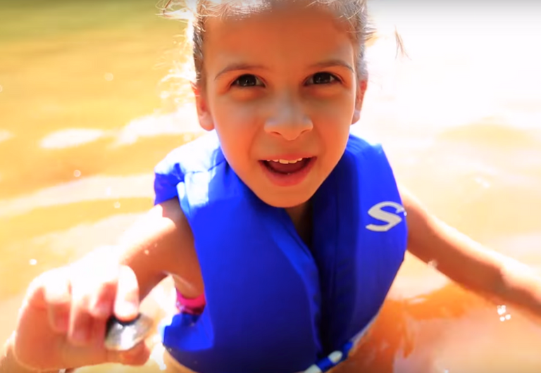 A child in a lifejacket in the water. 