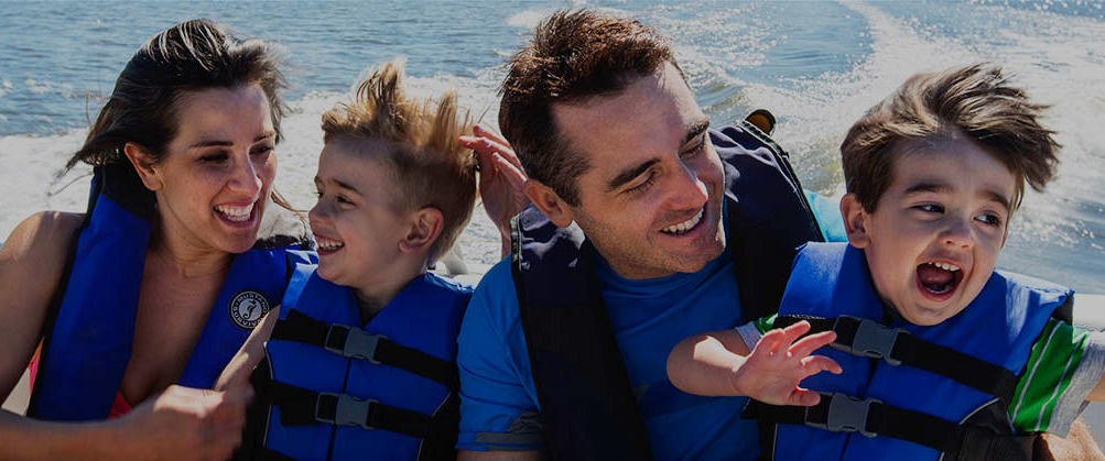 A family wearing lifejackets on a boat, boat safety concept. 