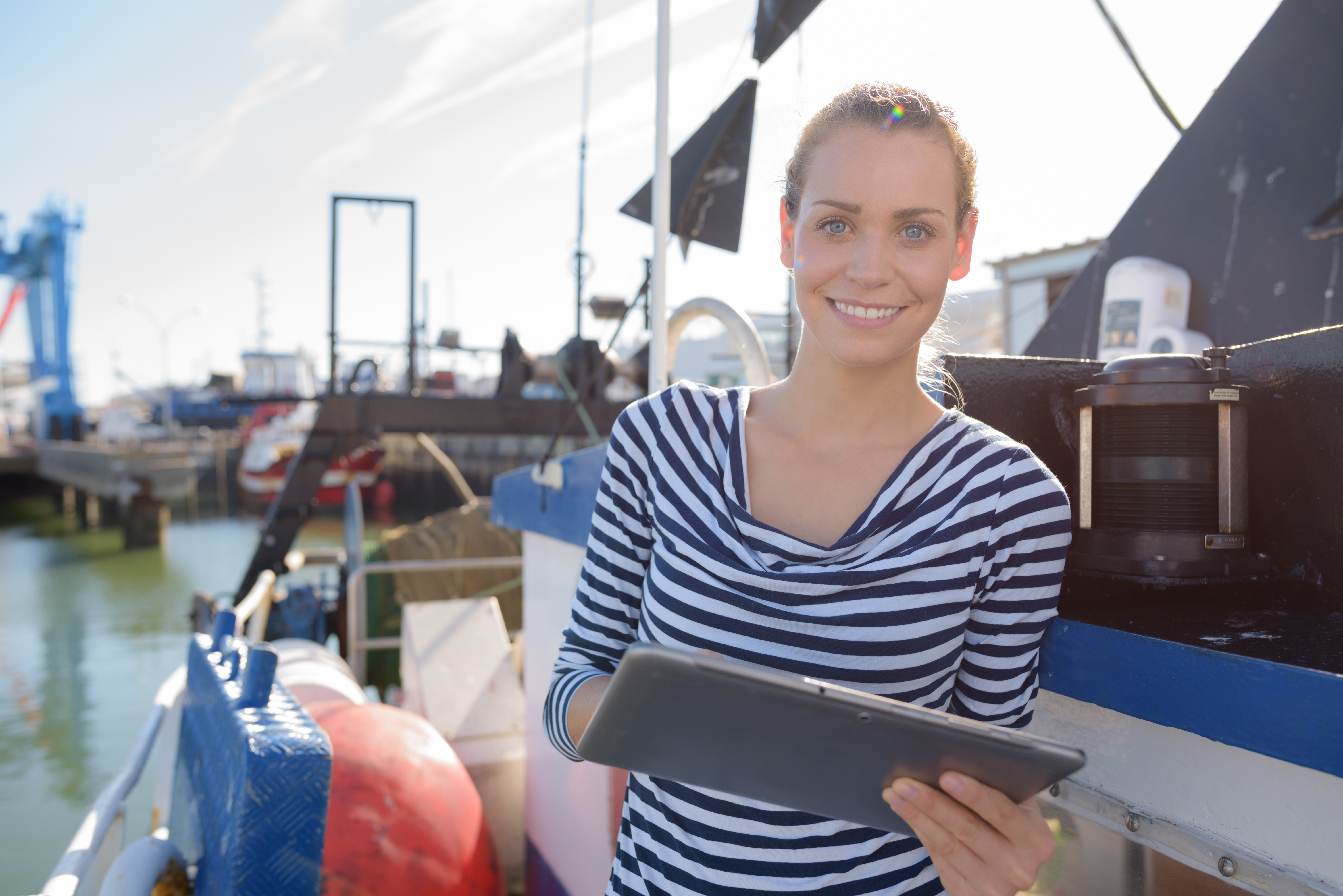 A woman holding a clipboard on a boat, boat insurance concept. 