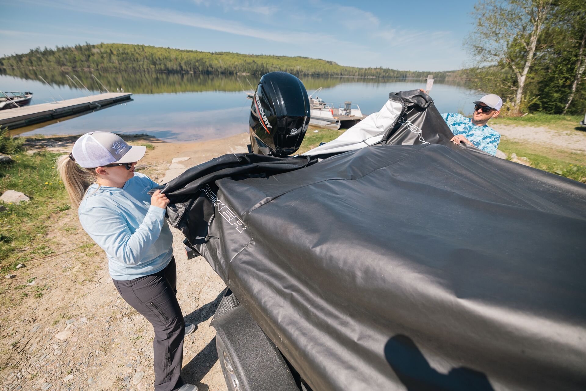 Two boaters handle boat cover on boat, how to winterize a boat concept.